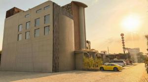 a yellow car parked in front of a building at Lumeirrah Suites in Moga
