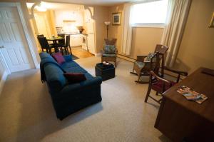 ein Wohnzimmer mit einem blauen Sofa und Stühlen in der Unterkunft Shipwright Inn in Charlottetown