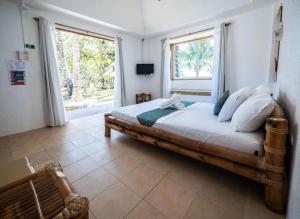 a bedroom with a large wooden bed with a window at Elysia Beach Resort in Donsol