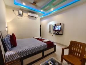 a bedroom with a bed and a tv and a chair at Sea Wander Beach Resort in Mandarmoni