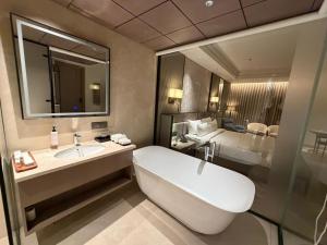 a bathroom with a sink and a tub and a bed at Lumeirrah Suites in Moga +13 photos