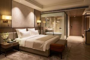 a bedroom with a large bed and a bathroom at Lumeirrah Suites in Moga