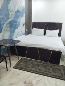 a bedroom with a bed with a table and a wall at Hotel Ienvo Inn in New Delhi