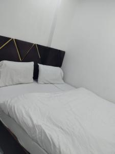 a large white bed with two pillows on it at Hotel Ienvo Inn in New Delhi