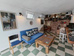 a living room with a blue couch and a table at Skalolazka 2 in Belogradchik