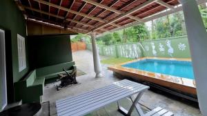 a patio with a swimming pool and a bench at White Cloud Stay Attappadi in Agali