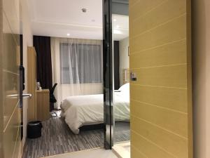 Rúm í herbergi á Hotel Pomelo Premier 西柚臻选武昌站酒店