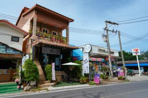 a building with a clock on the side of a street at Passion Nai Harn Guesthouse in Nai Harn Beach