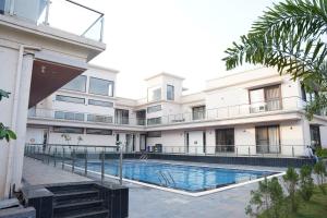 an exterior view of a building with a swimming pool at Estrella The Resort in Karjat