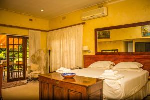 a bedroom with a bed and a table with towels at 12 FLEETWOOD in Harare +36 photos