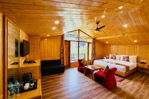 a bedroom with a bed and red chairs in a room at Hotel Mount Manali - The Cozy Stay in Vashisht