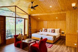 a bedroom with a bed and a table and chairs at Hotel Mount Manali - The Cozy Stay in Vashisht