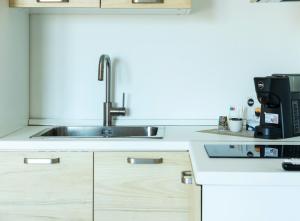 a kitchen with a sink and a coffee maker at Comfyrooms in Quartu SantʼElena +14 photos