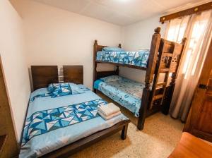 a bedroom with two bunk beds and a chair at Hostal, casa Jaramillo in Roldanillo