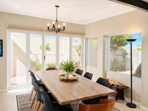 a dining room with a wooden table and chairs at Sandy Toes Home in Plettenberg Bay