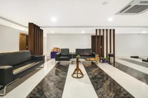 a lobby with couches and a table in a building at Hotel O D Suites in Hyderabad +36 photos