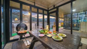 a table with plates of food and a grill at Gapeong Jason Spa Pension in Gapyeong