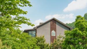 a house with trees in front of it at Gapeong Jason Spa Pension in Gapyeong +2 photos