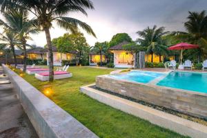 a villa with a swimming pool and palm trees at Sea Coco Resort in Ban Pak Nam Khem Nu