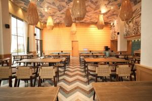 a restaurant with tables and chairs in a room at Estrella The Resort in Karjat