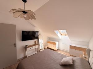 a bedroom with a bed and a tv on the wall at Appartement neuf à louer in Moyenmoutier