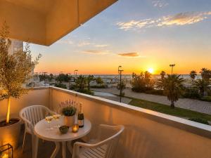 a table and chairs on a balcony with a sunset at Hotel Executive La Fiorita in Rimini