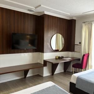 a hotel room with a desk and a mirror at Queen Margarette Hotel in Silañgang Isabang