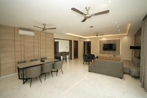 a living room with a ceiling fan and a table and chairs at Estrella The Resort in Karjat