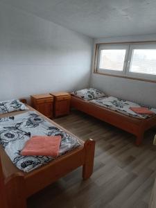 a room with two beds and a window at Kerka Szállás in Kerkabarabás