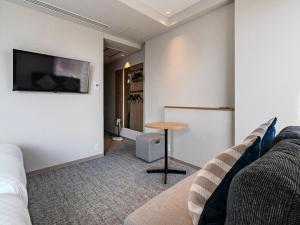 a living room with a couch and a table at Meitetsu Inn Nagoyaeki Shinkansenguchi in Nagoya