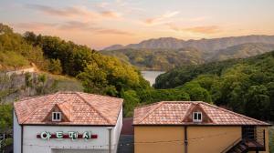 two buildings with a view of a river and mountains at Gapyeong Art Pension in Gapyeong