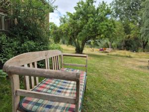 a wooden bench with a plaid blanket sitting in the grass at Grüne Idylle in Borrentin