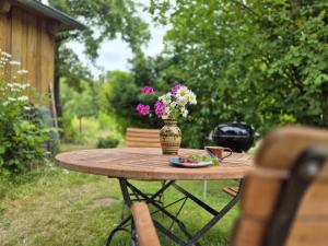 a table with a vase with flowers on it at Grüne Idylle in Borrentin