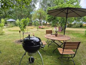 a bbq grill and a table with an umbrella at Grüne Idylle in Borrentin