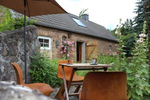 a table and chairs in front of a brick house at Grüne Idylle in Borrentin