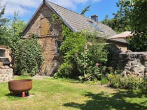 a brick house with a barrel in the yard at Grüne Idylle in Borrentin +59 photos