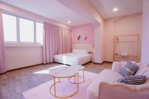 a living room with a couch and a table at Hugstore Pink Hotel in George Town +15 photos