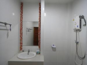 a white bathroom with a sink and a shower at Phakawan Hotel in Ban Nong Chik