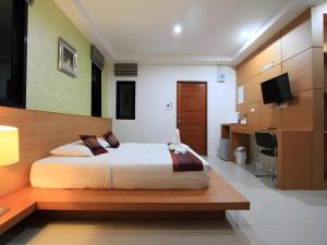 a bedroom with a large bed and a desk at Phakawan Hotel in Ban Nong Chik