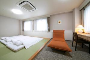 Yokaichi Royal Hotel في Yōkaichi: غرفة نوم بسرير ومكتب وطاولة