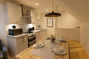 a kitchen with a table with plates and wine glasses at Harbourside, Shetland Islands in Lerwick +19 photos