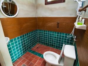 a bathroom with a toilet and a green tiled floor at Pangsarapee Resort in Ban Bo Nam Khao +30 photos