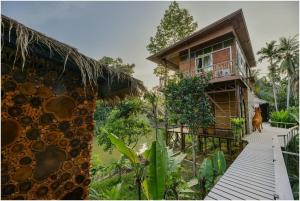 a house with a dog standing in front of it at Tamsabai Resort in Ban Na Nian