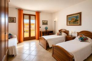 a hotel room with two beds and a balcony at La casa del viaggiatore in Codrongianos