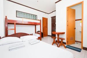 a bedroom with a bed and a desk and a table at Mayon Backpackers Hostel in Legazpi +133 photos
