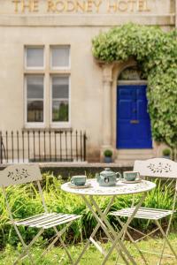 a table and chairs in front of a building with a blue door at The Rodney Hotel in Bristol