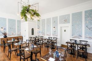 a restaurant with tables and chairs in a room with wallpaper at The Rodney Hotel in Bristol