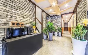 a lobby with potted plants and a brick wall at Dapsimni Hotel Grim in Seoul