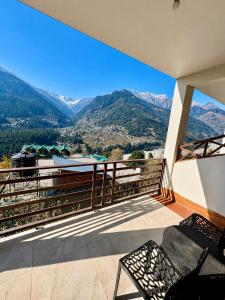 a balcony of a house with a view of mountains at Hotel Mount Manali - The Cozy Stay in Vashisht