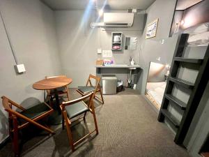 a room with a table and chairs and a bunk bed at Rhodes Otsuka Hotel in Tokyo